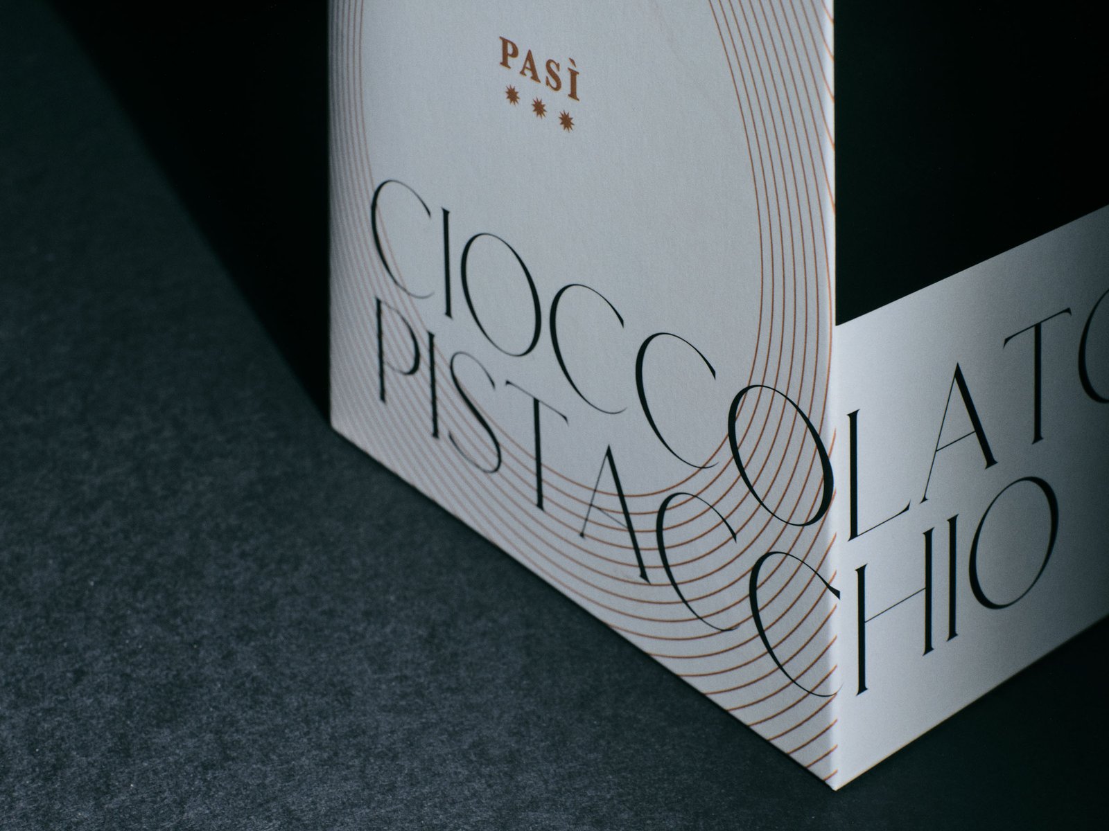 The name Cioccolato al pistacchio turning the edge of the white Pasì box