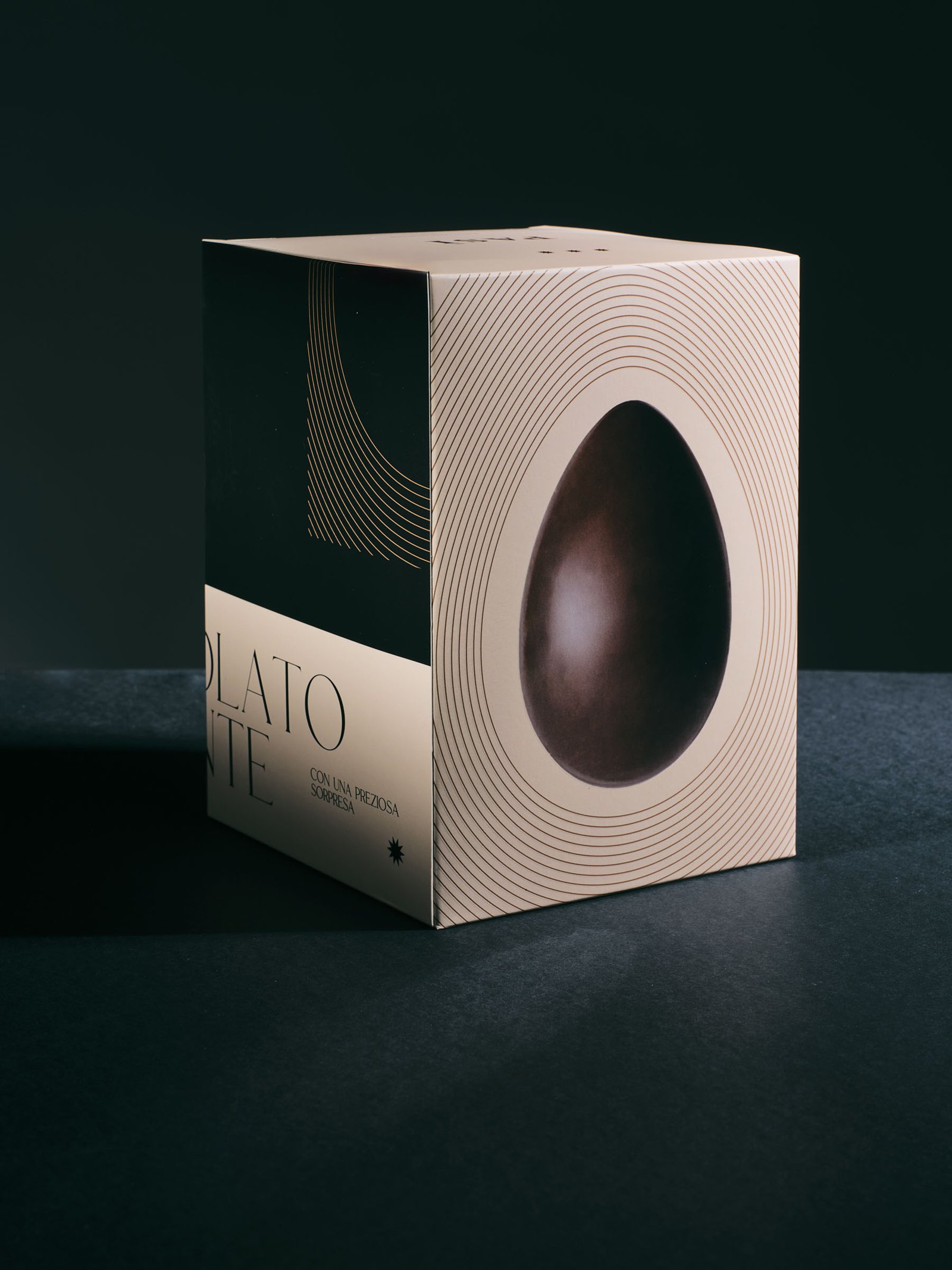 Pasì Cioccolato fondente box, ivory, standing with the dark chocolate egg on its side face