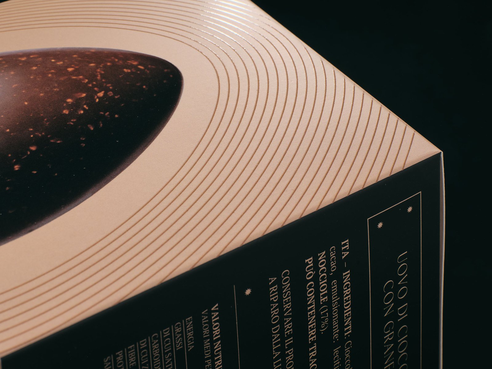Detail of the Pasì Fondente & Nocciole lid: the egg with its hazelnut pieces and fine copper lines around it
