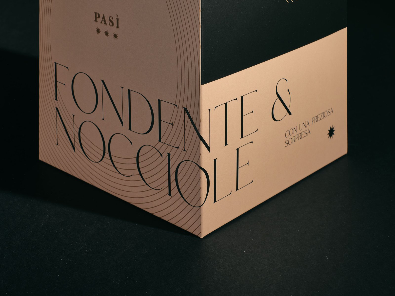 The name Fondente & Nocciole turning the edge of the Pasì box, from one face to the next