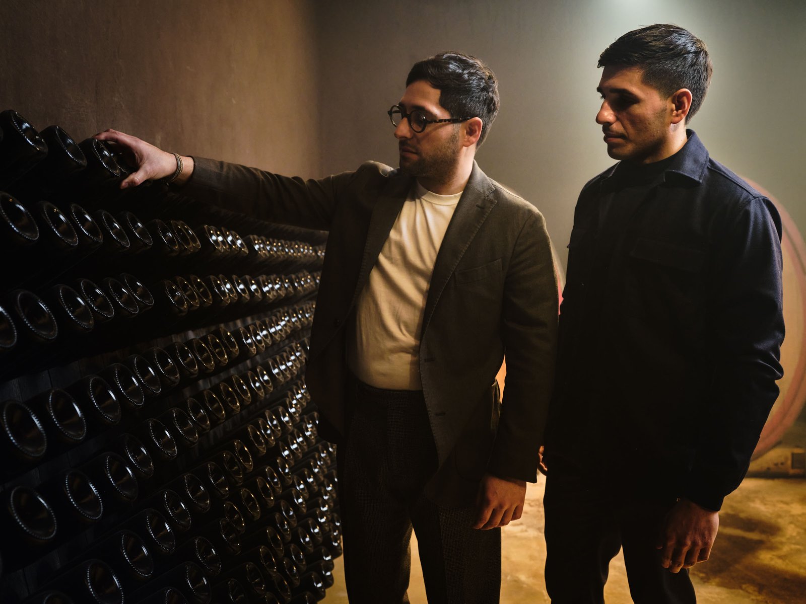The owners in front of the stack of bottles lying on their sides
