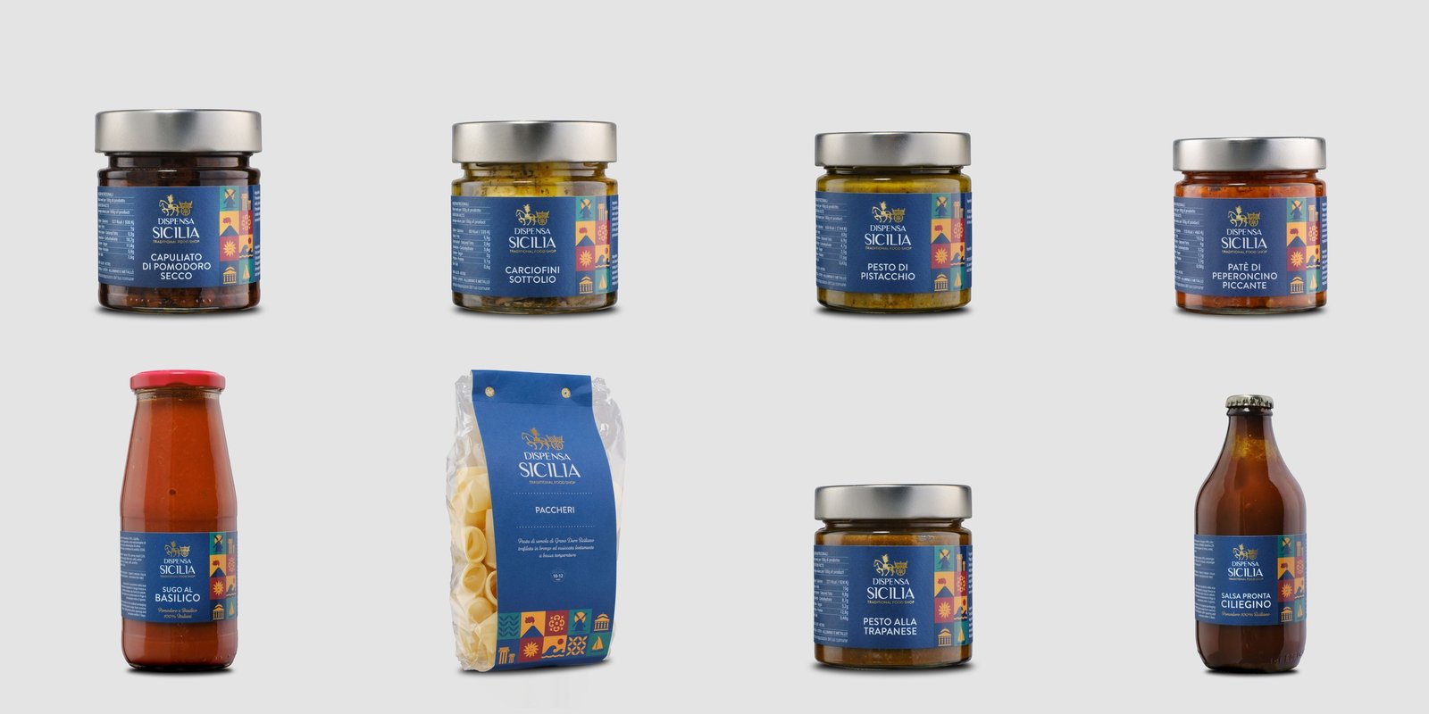 Eight Dispensa Sicilia products on a light background, in two rows: jars of chopped dried tomato, artichokes in oil, pistachio pesto and hot chilli pâté, then basil sauce, paccheri, pesto alla trapanese and cherry tomato sauce