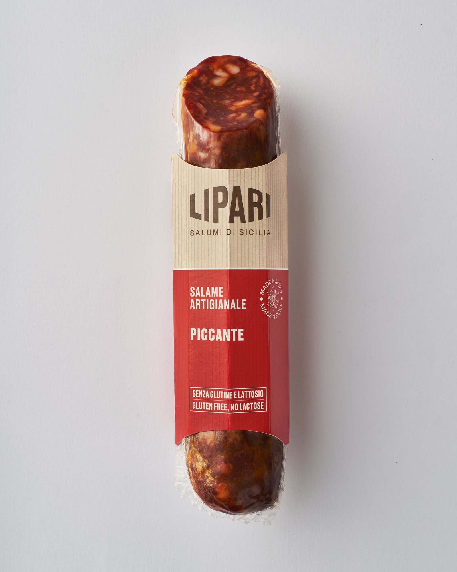 Packshot del salame artigianale Piccante nella fascetta Lipari, su fondo chiaro