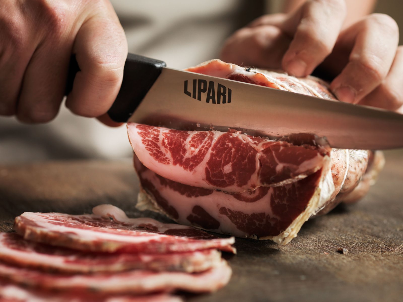 Il coltello Lipari affetta una pancetta coppata: la fetta appena tagliata mostra il suo disegno