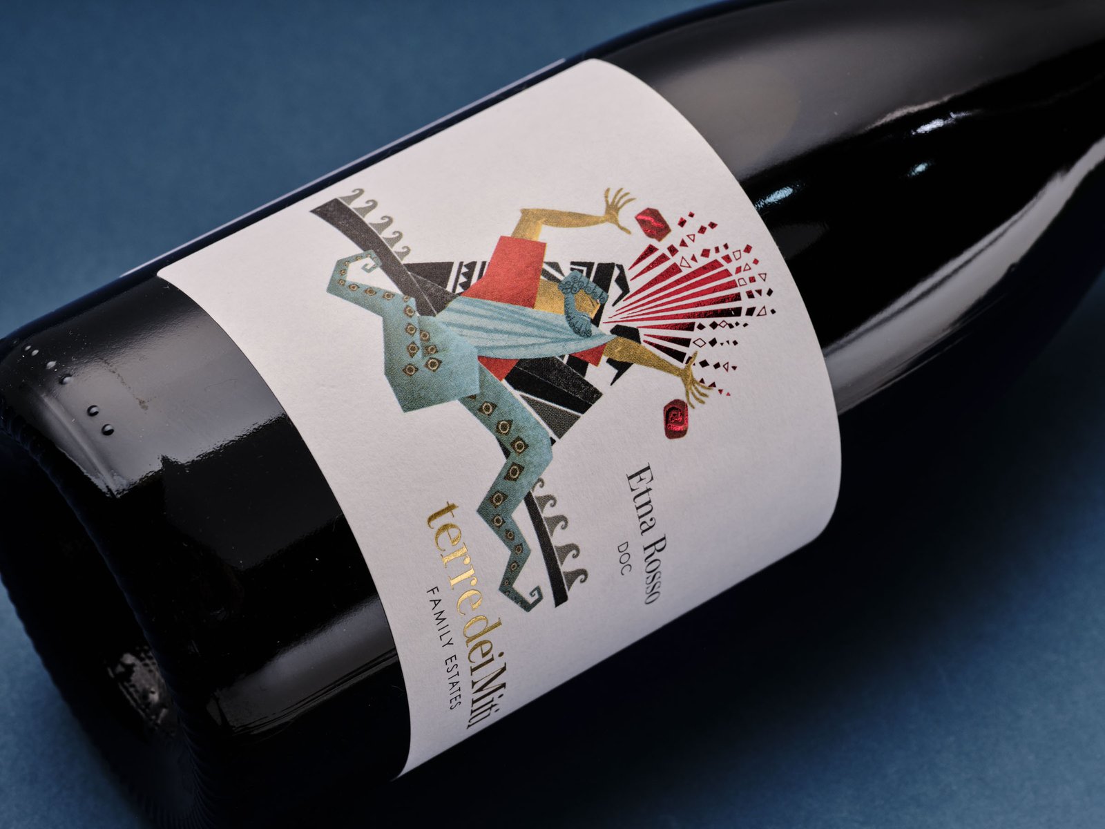 Detail of the Terre dei Miti Etna Rosso label: the metallic red shards bursting from the hands of Enceladus